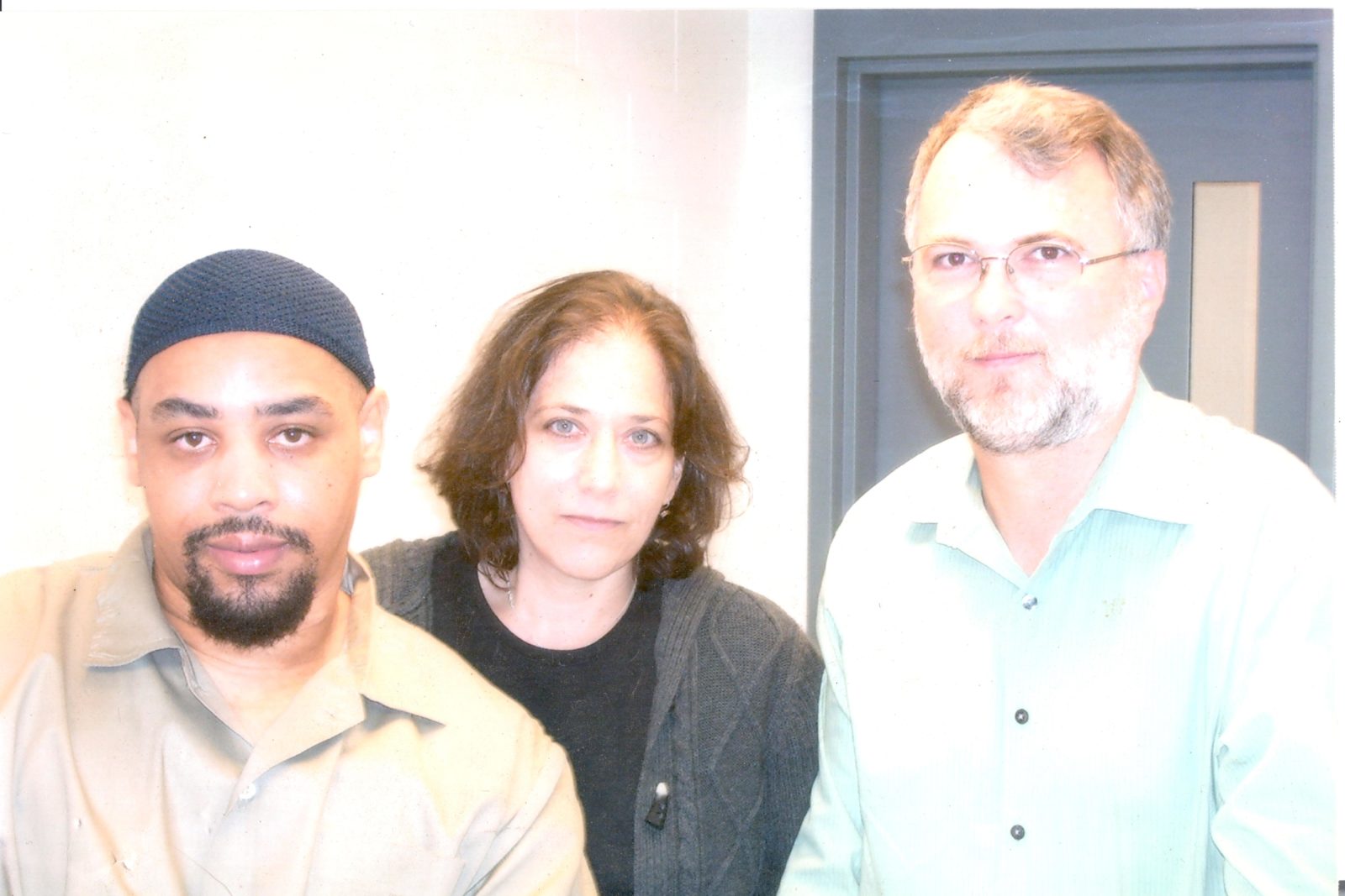A photograph of Orlando Hall, left, next to attorney Marcy Widder, center, and attorney Rob Owen, right. 